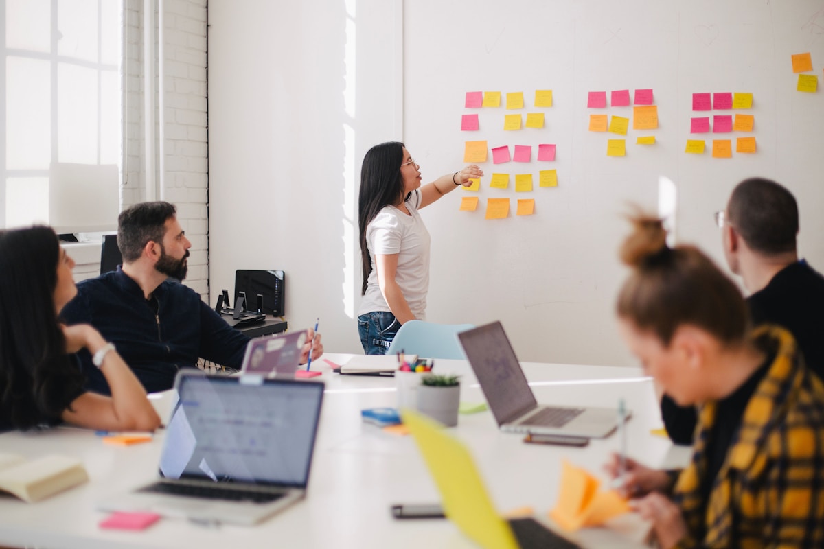 A small team mapping a flow on sticky notes around a shared studio table