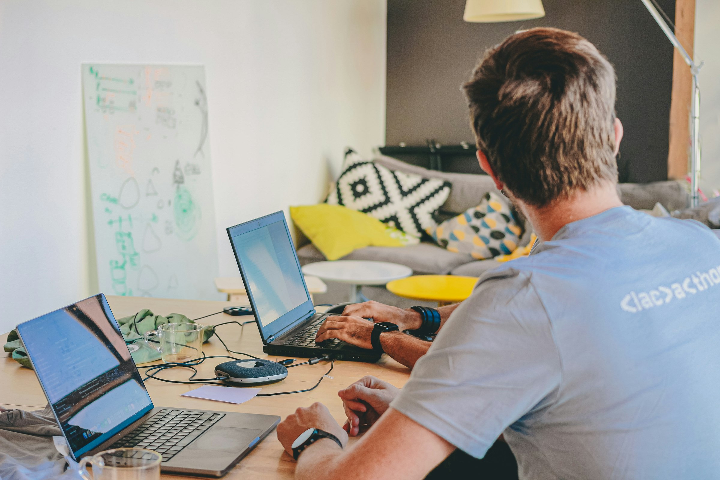 Developer working across multiple laptops at a desk