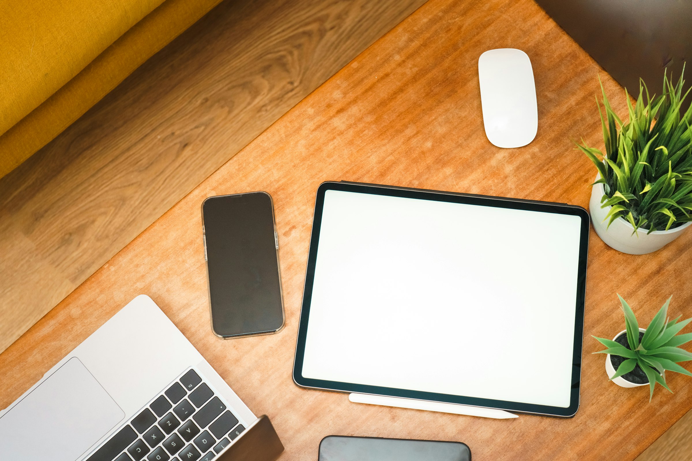 Phone, laptop and tablet arranged on a desk (one identity context across multiple devices)